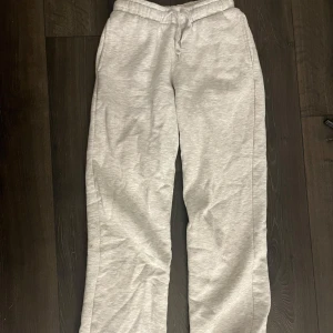 Grå mjukisbyxor från Gina Tricot XXS - Säljer ett par ljusgrå mjukisbyxor från Gina Tricot i storlek XXS. De har elastisk midja med snörning och raka ben. Säljer då dom inte kommer till användning. 