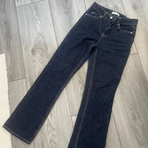 Mörkblå  jeans från Ginatricot - Snygga mörkblå jeans från Ginatricot med klassisk bootcut passform. Jeansen har kontrastsömmar, fem fickor och dragkedja med knapp framtill. Perfekt längd för 160