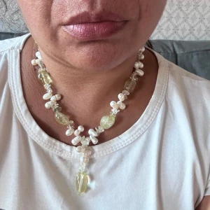 SCOOP pärlhalsband med silverdetaljer - Unikt halsband från SCOOP med äkta sötvattenspärlor, ljusgula glaspärlor och detaljer i 925 silver. Halsbandet har en cool mix av former och pärlor, med en droppformad hängande pärla i mitten. Perfekt för dig som gillar statement-smycken och vill sticka ut.