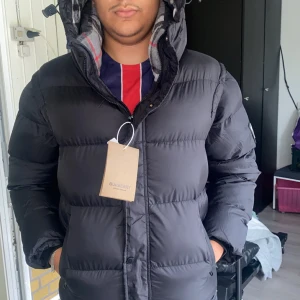 Svart pufferjacka från Burberry - Svart pufferjacka från Burberry med avtagbara ärmar så den kan användas som väst jackan är i storlek M