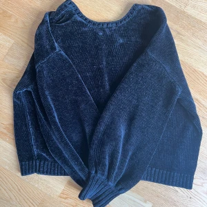 Svart chenille-tröja från Bik Bok - Säljer en svart tröja från Bik Bok i mjuk sammetsliknande chenille med ribbade muddar och v-ringning i nacken.