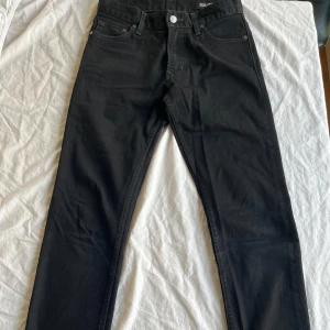Svarta 302 skinny jeans från Crocker - Svarta Crocker 302 Skinny jeans med klassisk femficksdesign och snygga detaljer som silverfärgad knapp och dragkedja. Jeansen har smal passform och är tillverkade i stretchig bomull för en bekväm känsla. Perfekt för dig som gillar en stilren och enkel look. I väldigt fint skick, hels och rena. Storlek W27L32. 