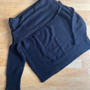 Svart offshoulder stickad tröja NA-KD - Säljer en svart stickad tröja från NA-KD i storlek M. Tröjan har en snygg offshoulder-design och långa ärmar med ribbade muddar.