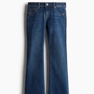 Blå Low bootcut jeans  - Snygga blå jeans från Levi's med klassisk bootcut-passform. Jeansen har fem fickor, knapp och dragkedja framtill samt subtila slitningar för en cool look. Perfekta för dig som gillar retrovibbar och vill ha ett par jeans med lite extra sväng i benen.