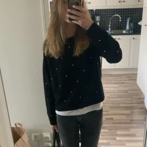 Stickad tröja med pärlor - Svart stickad tröja från H&M i storlek XS. Tröjan har ett coolt pärlmönster över hela framsidan och är långärmad med en lite loose passform. Perfekt att styla med jeans eller kjol för en chill look. Rund halsringning och mjukt material. Jättemysig tröja och perfekt till skolan.