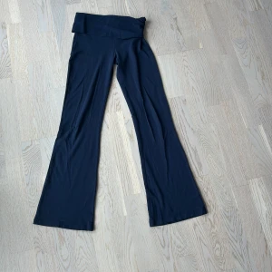Yoga pants - Supersköna mörkblå mjukisbyxor med bootcut och låg midja. Perfekta för chill dagar eller när du vill ha något bekvämt men ändå snyggt. Där uppe viker man ner byxorna. Mycket använda men fortfarande bra skick!