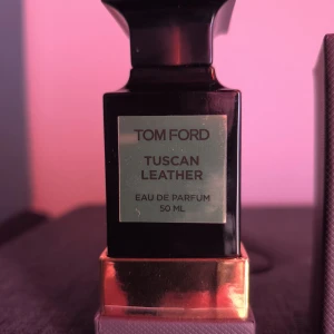 Tom Ford Tuscan Leather 50ml EdP - Exklusiv parfym från Tom Ford, Tuscan Leather, Eau de Parfum 50 ml. Flaskan är svart med guldiga detaljer och har en lyxig, fyrkantig design. Kommer i en elegant grå kartong med struktur. En ikonisk doft med lädertoner och modern känsla. Enbart testsprayad.