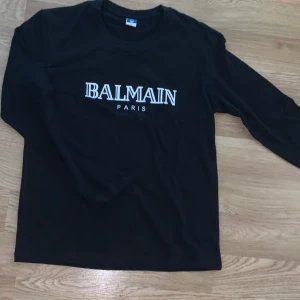 Balmain tröja - Svart långärmad tröja från Balmain Paris med vit text, säljer då den var för liten på mig, helt oanvänd 