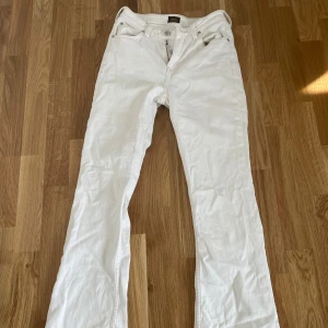 Vita bootcut jeans Lee Breese Boot - Snygga vita jeans från Lee, modell Breese Boot med bootcut-ben. Klassisk femficksdesign, normal passform och tillverkade i bomull. Perfekta för dig som vill ha en fräsch och stilren look med lite retrovibbar.