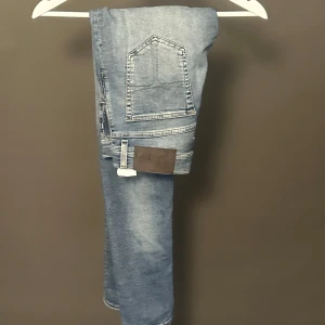 Slim jeans Tiger of Sweden ljusblå - Snygga ljusblå slim fit jeans från Tiger of Sweden. Klassisk femficksmodell med diskreta slitningar och normalhög midja. Jeansen är i stretchig bomullsdenim och har en stilren look med ljusa tvättade partier och smala ben.