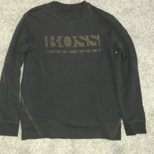Svart långärmad tröja från Hugo Boss - Svart långärmad tröja från Hugo Boss. Storlek M men är lite liten. Väldigt bra skick har inte använt den så mycket.