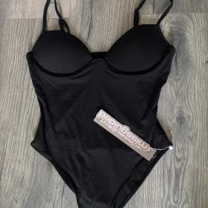 Svart body från Missguided - Snygg svart body från Missguided med vadderade kupor och justerbara axelband. Liten i storlek passar mig som har S men står L