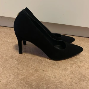 Svarta pumps i mocka från Novita - Klassiska svarta pumps från Novita i mjuk mocka med spetsig tå och smal klack. Använd 2 gånger. 