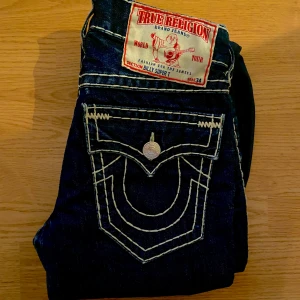 True Religion Jeans Billy Super T - Feta true religion Billy super t jeans, storlek 30x34 och i bra skick. Passar större. Har dock lite heelbite.  Vädigt sälssynt par där de är bootcut och mörkblå. Mått: Midja 41, Längd 112, Innerben 86 och Ben öppning 24.5cm. Sädda på sematary i rb2 albumet 💩 🗑️ Skriv om ni undrar någonting 📲💯