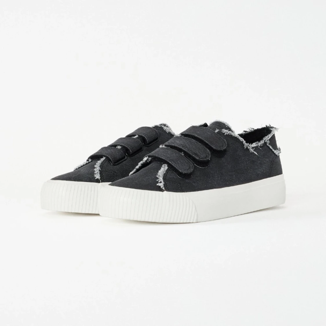 Svarta sneakers med fransade kanter