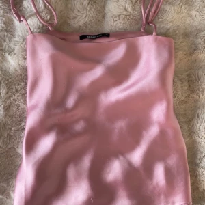 Rosa satinlinne från Gina Tricot - Supersött ljusrosa linne från Gina Tricot, slutsålt och funkar både som festtopp eller pyjamas, både skön och fin. 