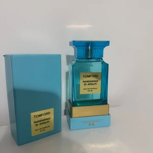 Tom Ford Mandarino di Amalfi 100ml - Fräsch och lyxig parfym från Tom Ford, Mandarino di Amalfi, i en snygg blå glasflaska med guldiga detaljer. Flaskan rymmer 100 ml Eau de Parfum och kommer i en matchande blå kartong. Perfekt för dig som gillar exklusiva dofter med citrusinslag.