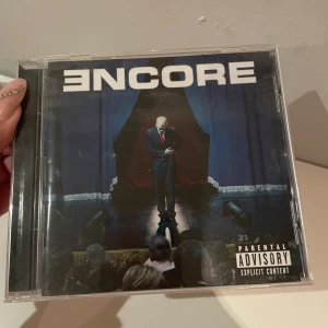eminem cd - Encore är ett ikoniskt album av Eminem, perfekt för dig som älskar rap och vill ha en klassiker i samlingen. Med låtar som 'Just Lose It' och 'Mockingbird' är detta ett måste för alla som gillar starka texter och beats. Skivan har coolt omslag och exklusivt häfte.
