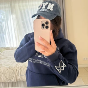 Unik mörkblå keps med tryck  - Snygg blå keps med broderad vit NYC-text framtill och mindre röd detalj. Kepsen har böjd skärm och justerbar passform. Säljer en vinröd keps med NYC-brodyr framtill och textdetaljer. Jättemorden keps! Köpt i på en butik i New York!