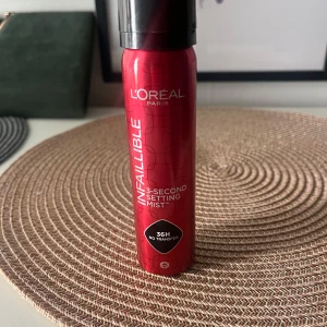 L'Oréal Infaillible Setting Mist - L'Oréal Infaillible 3-Second Setting Mist i en snygg röd metallflaska. Ger makeupen en hållbar finish i upp till 36 timmar utan att smeta av sig. Perfekt för att fixera sminket snabbt och enkelt. Sprayen är lätt och kommer i en praktisk sprayflaska.