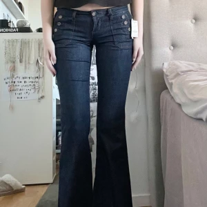 Super lågmidjade jeans - per lågmidjade jeans med coola knappar som detaljer. Storlek 5, motsvarar en XS/S. Mått = midja: 37cm tvärs över, från skrevet och upp: 18cm, innerbenslängd: 84cm. Perfekt längd för mig som är 175! 🤍 Helt oanvända, lapparna kvar. 