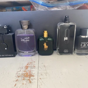 Parfymset med fem olika herrdofter - Fem olika herrparfymer: Club de nuit, Hawas For Him, Ralph Lauren Polo Green, Afnan 9 pm och Acqua di Giò från Giorgio Armani. Flaskorna har olika former och färger, från svart till grön och transparent. Tar emot bud, alla är ungefär 80% fulla förutom aqcua di gio som har 40% kvar
