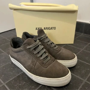 sneakers från Axel Arigato - Säljer ett par stilrena sneakers från Axel Arigato i mocka. Strl 43 men passar mig som har 44. Finns något mindre svart märke på sulan på den ena skon.