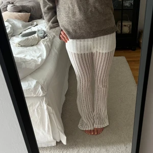 Vita virkade byxor med utsvängda ben - Säljer ett par vita virkade byxor med utsvängda ben och insydda shorts. Från bershka i storlek S!❣️ser ut som nya!!