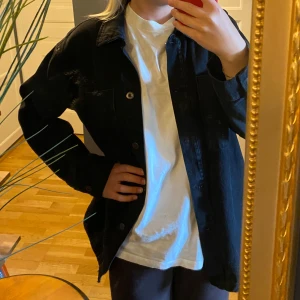 Svart/grå jeansjacka - Svart oversized jeansjacka! Lite längre också så den går över rumpan. Väldigt rak i formen, köpt från Lindex. Färgen är lite grå/svart. Sparsamt använd. Strl S men eftersom den är lite ovsersized så får man även plats med en tjockare tröja under!