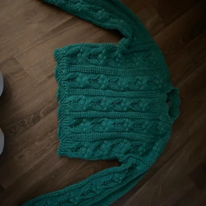Grön stickad tröja med mönster - Säljer en grön stickad tröja med vackert strukturmönster. Tröjan har lång ärm och är gjord i ett tjockare garn som passar perfekt för kyligare dagar. Den har en klassisk passform och är riktigt mysig. Den är storlek xs men är mindre än det skulle jag säga 