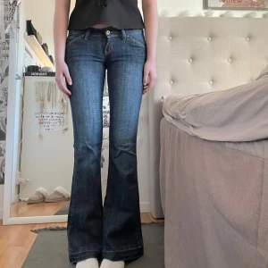 Mörkblå lågmidjade flared jeans - Jeans i mörkblå tvätt, låg midja. Storlek 38, medium. Fint skick, sparsamt använda. Mått = midja: 38cm, innerbenslängd: 84cm (perfekt längd på mig som är 175) från skrevet och upp: 18cm 🖤