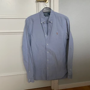 Ljusblå skjorta - Polo Ralph Lauren - Blå skjorta från Polo Ralph Lauren. Perfekt under en tröja. Storlek: S, slim fit. Skick:9/10, väldigt fint skick. Kontakta oss för fler bilder eller info!