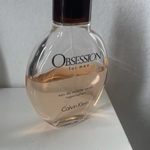 Obsession for Men Eau de Toilette - Obsession for Men från Calvin Klein är en klassisk herrparfym med varm och kryddig doft. Flaskan är oval i genomskinligt glas med brun kork och rymmer en ljus bärnstensfärgad vätska. Perfekt för dig som gillar tidlösa och maskulina dofter.