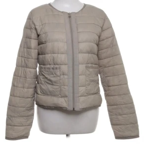 Beige quiltad jacka från Mango - Säljer en beige quiltad jacka från Mango Basics köpt på Sellpy. Jackan har rund halsringning, två fickor framtill och stängs med dragkedja. Som ny ungefär enligt mig, då jag aldrig använt den och det knappt syns annars.