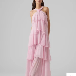 Ljusrosa volangklänning med halterneck - Säljer denna jätte fina klänning från Vero Moda. Den är uppen i ryggen och gick över mina fötter med klackar (är 168). Den är endast använd en gång och har original pris på 1199🌸