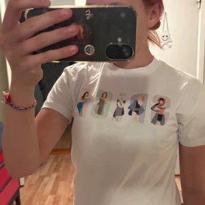 Vit Spice Girls t-shirt - Vit t-shirt med tryck av Spice Girls på framsidan och färgglad text på ryggen. Klassisk passform och rund halsringning. Perfekt för dig som gillar 90-talsvibbar och ikoniska band. Använd några gånger i sommras men annars inget alls. 