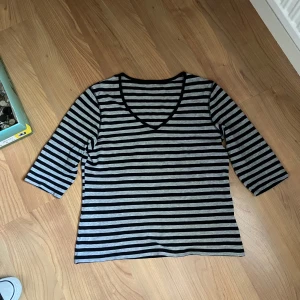 randig tröja - svart- och grårandig tröja med v-urringning och trekvartsärm.