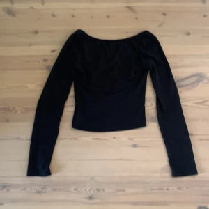 Svart långärmad topp från Gina Tricot - En svart långärmad topp från Gina Tricot med rundad halsringning. Även öppen rygg(djupringat) Enkel och stilren design som passar till många olika outfits. Perfekt basplagg i garderoben.