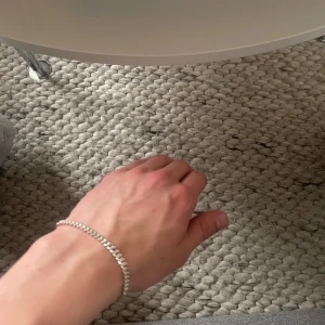 Silverfärgat armband - Snyggt och enkelt silverfärgat armband med en klassisk kedjedesign. Perfekt för att lägga till en subtil touch av stil till vilken outfit som helst. Armbandet har en praktisk låsning som gör det enkelt att ta på och av. Armbandet är 19 cm och köpt för 800 på guldfynd förra året 