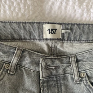 Grå jeans från 157 - Snygga grå jeansfrån 157 med klassisk femficksdesign och raka ben. Byxorna har bälteshällor, knapp- och dragkedjegylf samt en tvättad finish som ger en cool vintagekänsla.