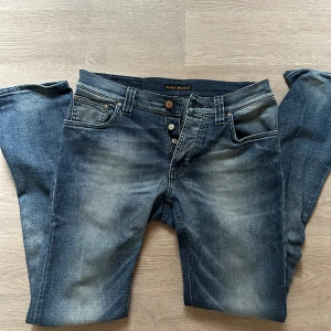 Nudie Grim Tim W31 - Sparsamt använda Grim Tim W31L34 i bra skick i snygg tvätt Clean Contrast.