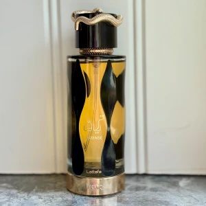 Teriaq Intense från Lattafa - Upptäck Teriaq Intense från Lattafa, en sexig unisexparfym med en djärv och kryddig doftprofil. Toppnoter av saffran och bergamott, hjärtnoter av plommonlikör och kanel, samt basnoter av amber, tonkaböna och benzoin. 100 ml, knappt använd, kommer i originalkartongen.