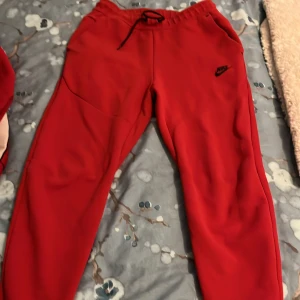 Röda mjukisbyxor från Nike - Säljer ett par röda Nike tech byxor som inte används längre storlek S skulle säga att det passar även M .