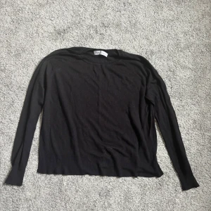Svart tröja från Zara - Säljer en stilren svart tröja från Zara. Tröjan har långa ärmar och en enkel design som passar perfekt till olika tillfällen. Tillverkad i ett mjukt material för extra komfort.