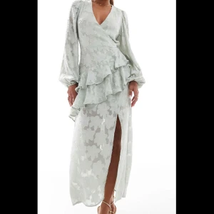 Klänning - Lång volangklänning i grön (ej använd)💚köpt från asos för strax under 700kr, säljer nu för 250+frakt😊klänningen är i storlek 38 och går till ankeln på mig som är 167 cm lång:) ”