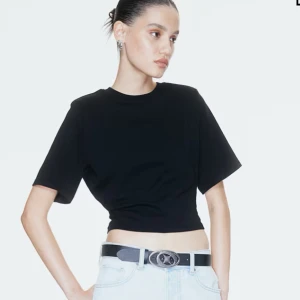 Svart croppad t-shirt - En svart figursydd t-shirt med vida ärmar. Enkel och stilren modell som passar perfekt till jeans eller kjol.