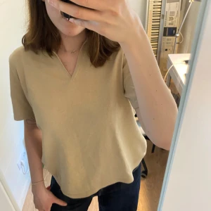 Beige pikétröja med v-ringning - Stilren beige pikétröja med v-ringning. Storlek 46 men passar utmärkt till M eller S!