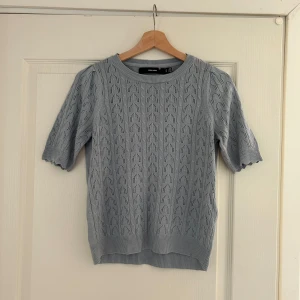 Ljusblå stickad topp från Vero Moda - Säljer en ljusblå stickad topp från Vero Moda med ett fint hålmönster. Toppen har korta ärmar och rund halsringning. Perfekt för vår och sommar! 💙