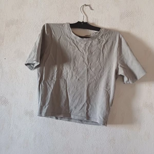 Grå t-shirt - Säljer en enkel och stilren grå t-shirt med korta ärmar. Perfekt för en avslappnad look. Passar bra till jeans eller shorts.