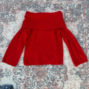 röd off-shoulder tröja - säljer en snygg röd stickad off-shoulder tröja från H&M. använd ett fåtal gånger. har en liten fläck på framsidan.